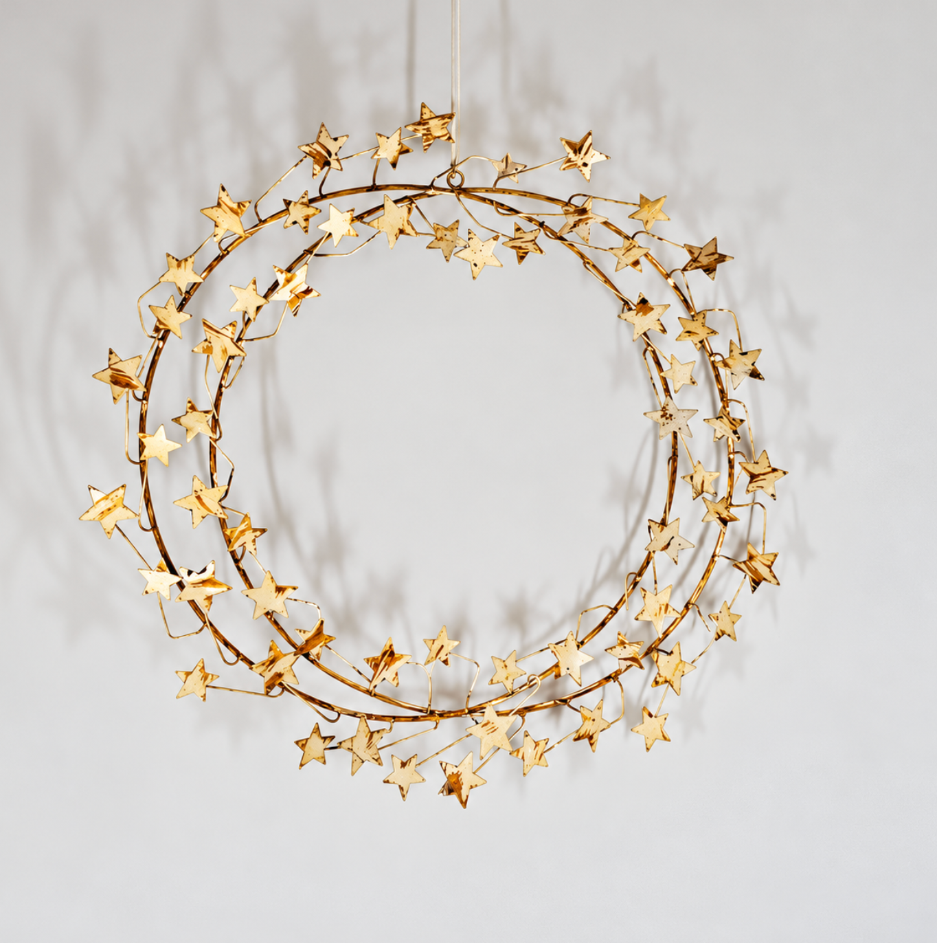 Gold-toned star wreath with layered star shapes on a circular frame