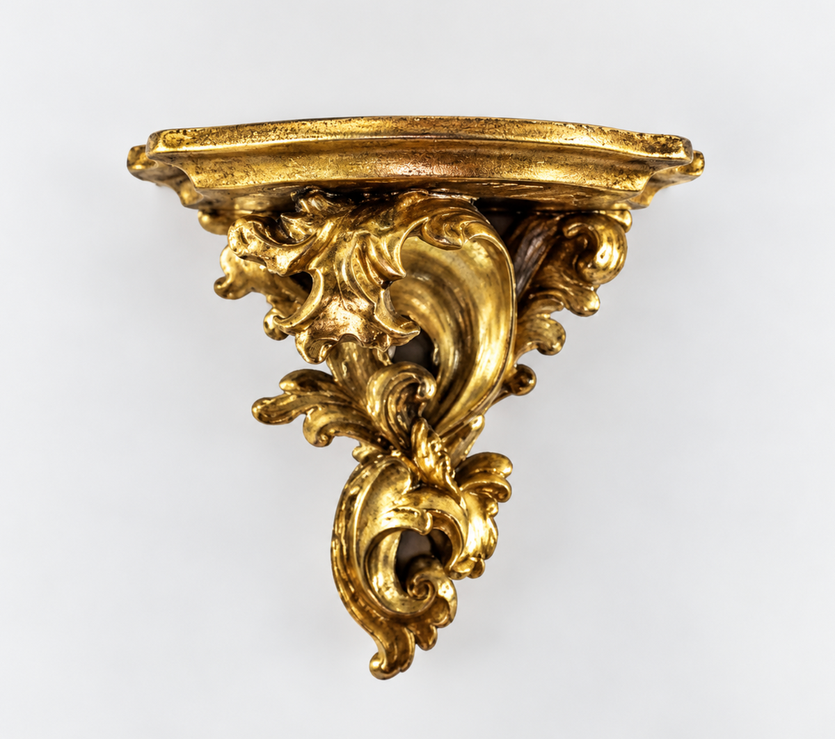 Gold-toned ornate baroque wall shelf with scrolling foliage and a shaped ledge
