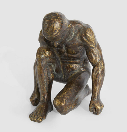 Resting man sculpture in antique finish viewed from the front