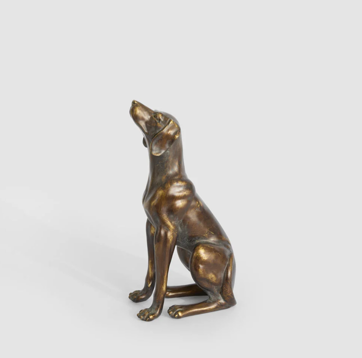 Sitting dog sculpture in antique finish viewed from the front