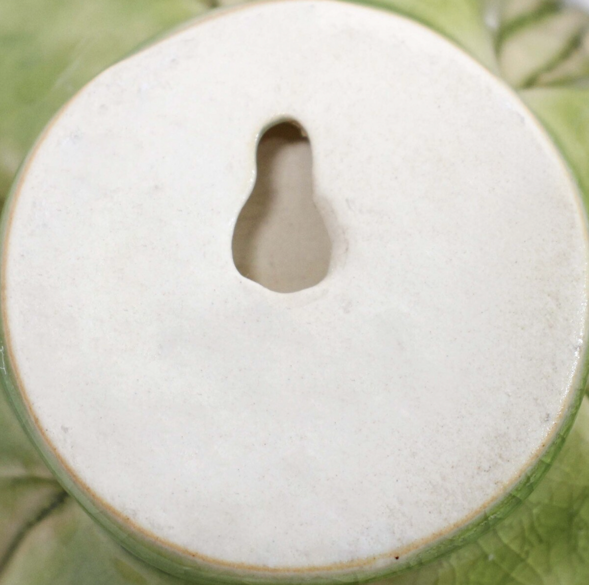 Back of mist ceramic wall flower showing keyhole hanger