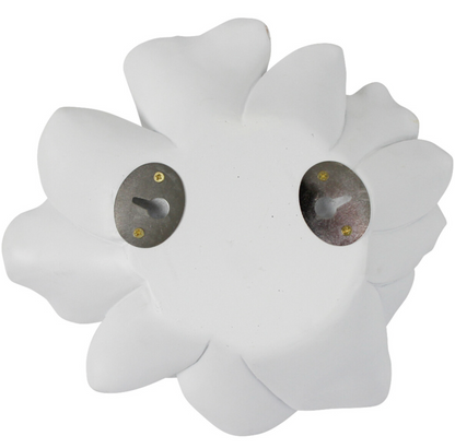 White magnolia flower sculptures displayed on a wall above a branch arrangement