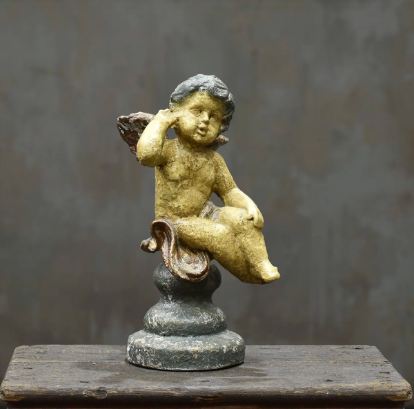 Close-up of dark aged cherub wing and sculpted body
