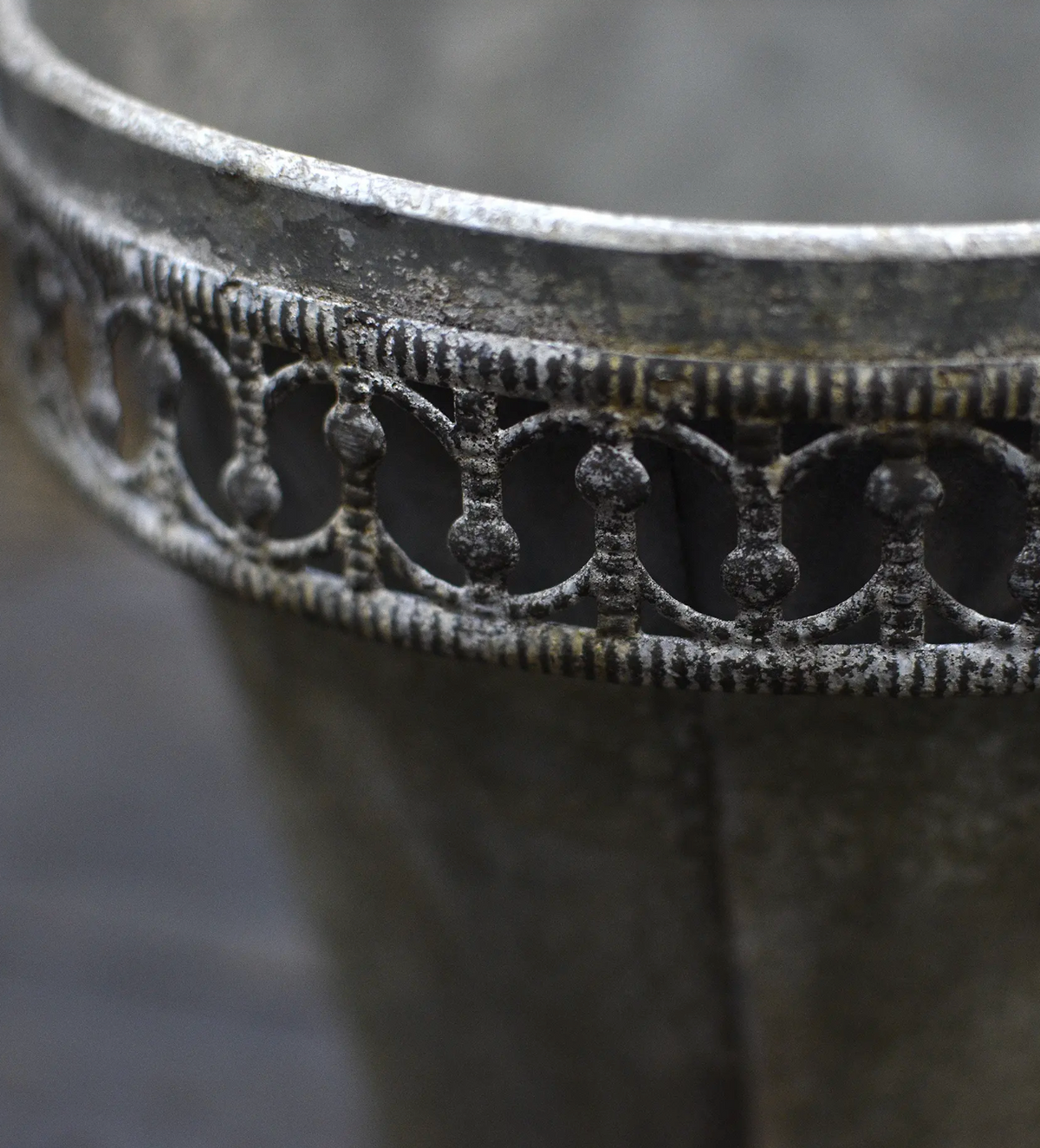 Tin flower pot with rolled lip and weathered patina, front view