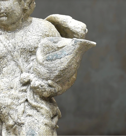 Close-up of cherub statue wing and drapery