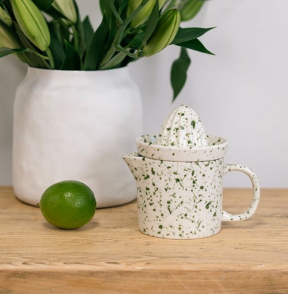 Green speckled juicer set with reamer removed beside the jug and a lime