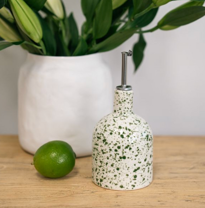 Rounded white bottle with green splatter and metal pouring spout