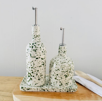 Rounded green splatter pourer bottle beside a lime