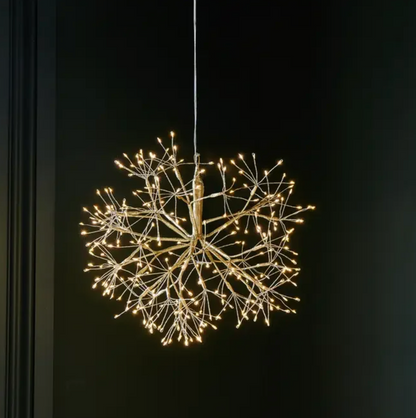 Gold hanging dandelion light glowing against a dark background