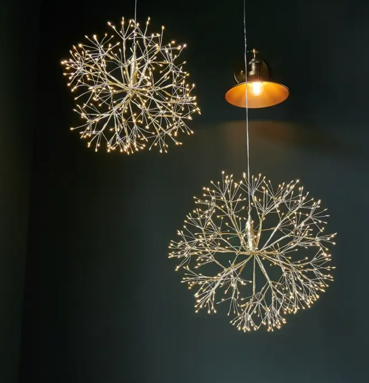 Close view of a gold hanging dandelion light with branching warm white LEDs