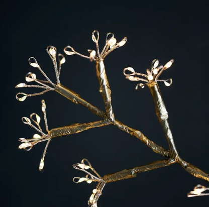 Snowflake hanging light with branched metal arms against a dark background