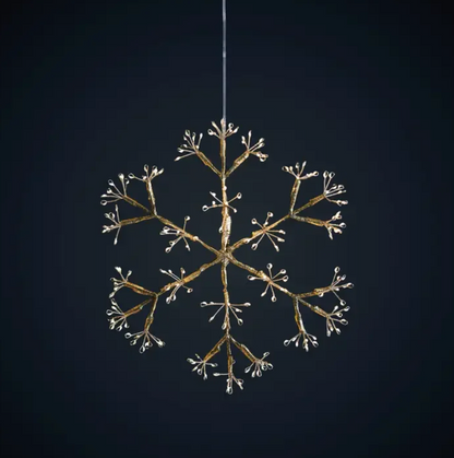 Four glowing snowflake hanging lights displayed above candles