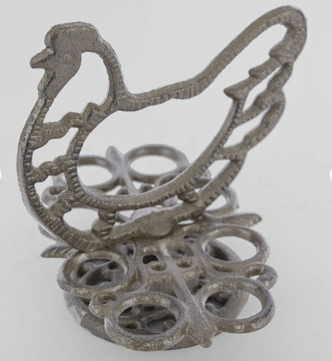 Cast iron chook egg holder with eggs arranged in its circular holders