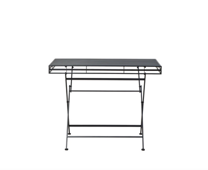 Angled view of black iron garden table with potted plants outdoors