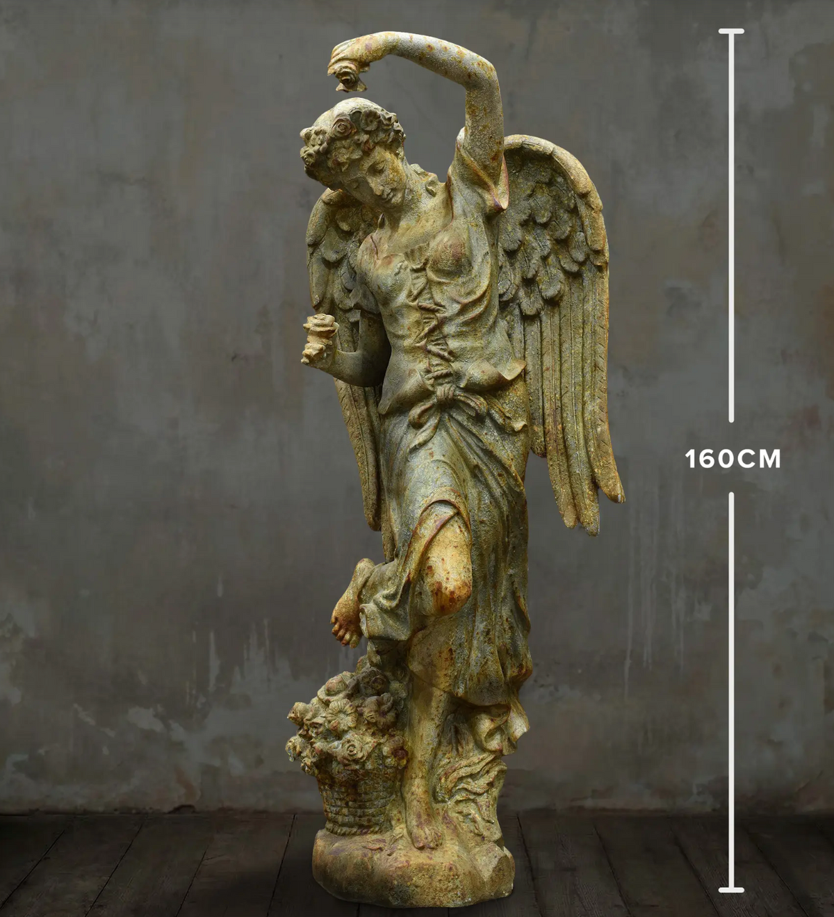 Full front view of angel statue with feathered wings and raised arm