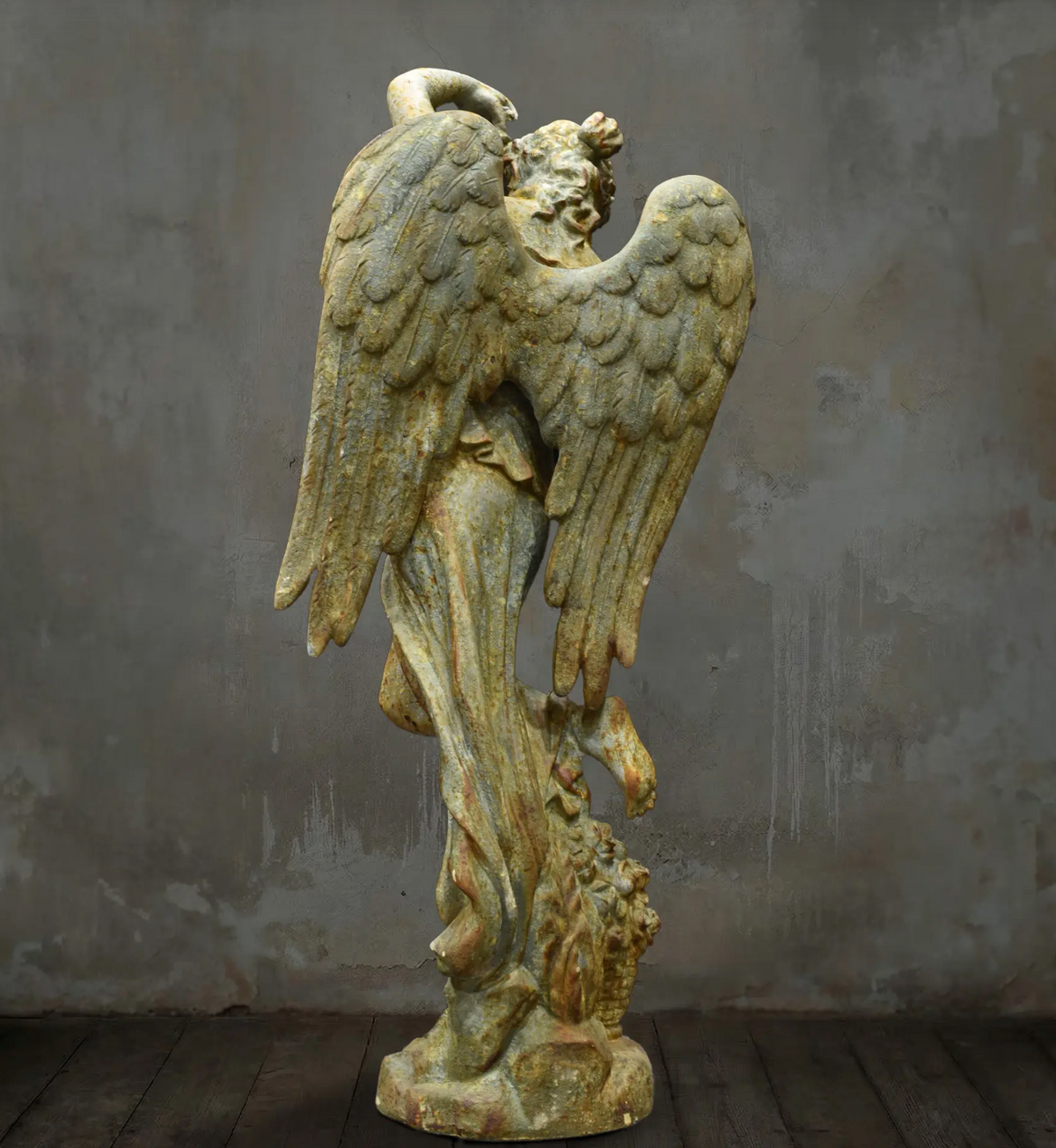 Angled front view of angel statue with floral detail at the base