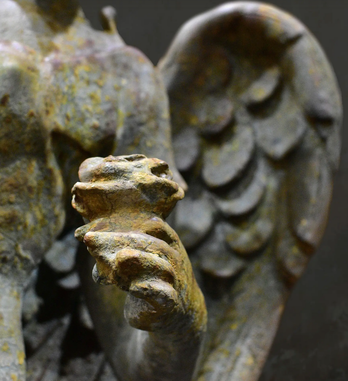 Close-up of weathered finish and sculpted drapery on angel statue