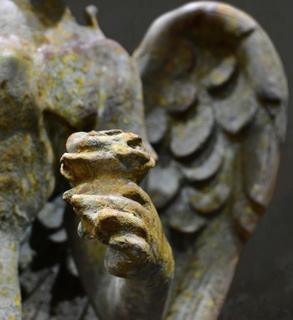 Close-up of weathered finish and sculpted drapery on angel statue