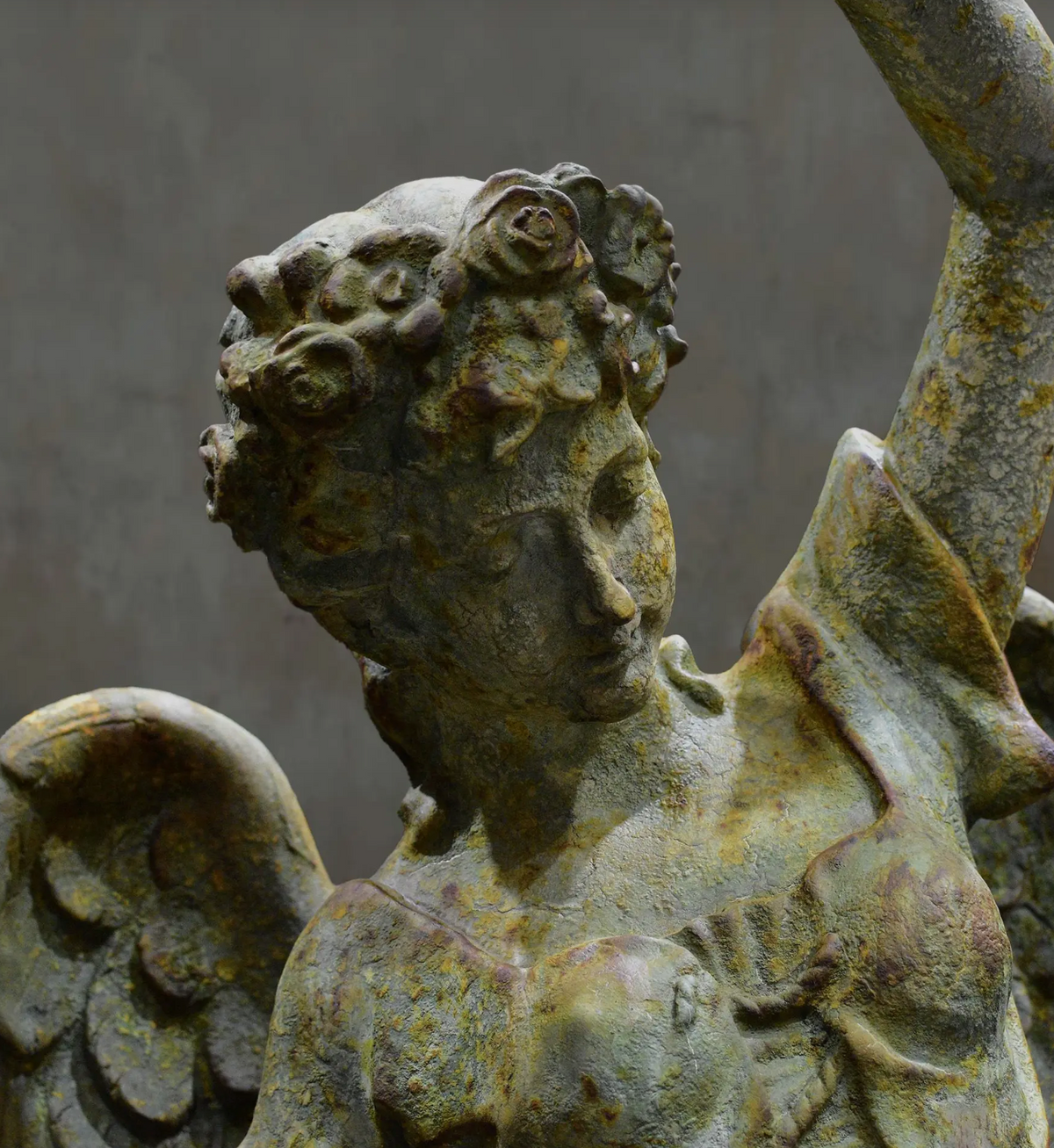 Side view of angel statue showing wing and draped clothing
