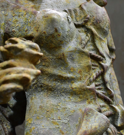 Close-up of angel statue hand with feathered wing behind it