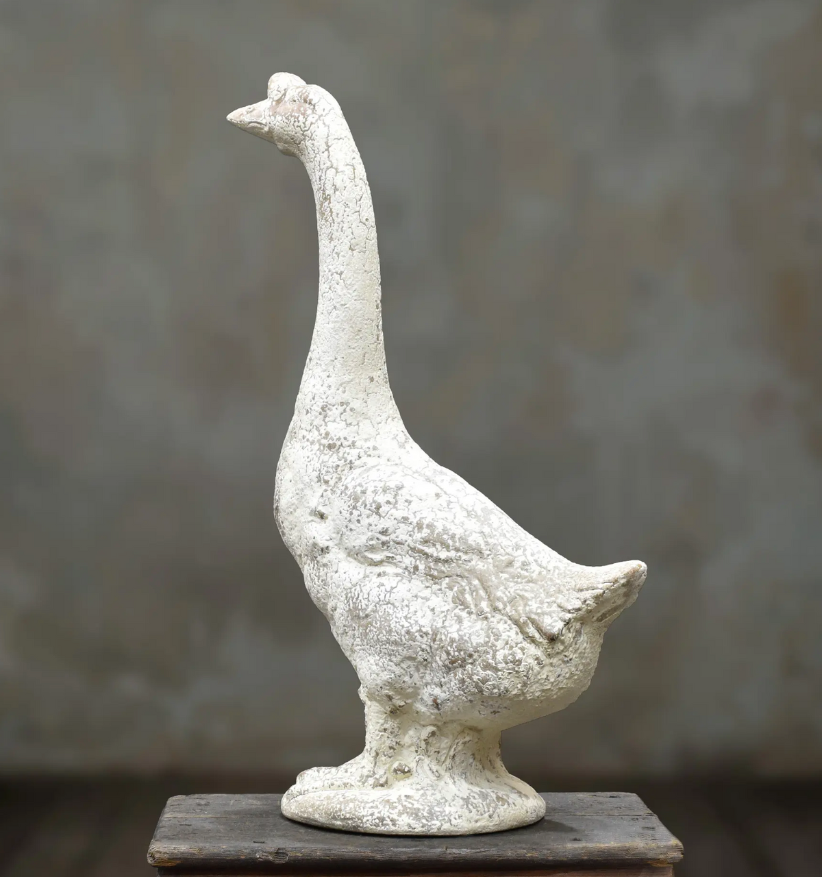 Rear view of standing goose statue with curved neck and sculpted tail