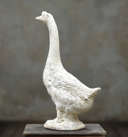 Rear view of standing goose statue with curved neck and sculpted tail