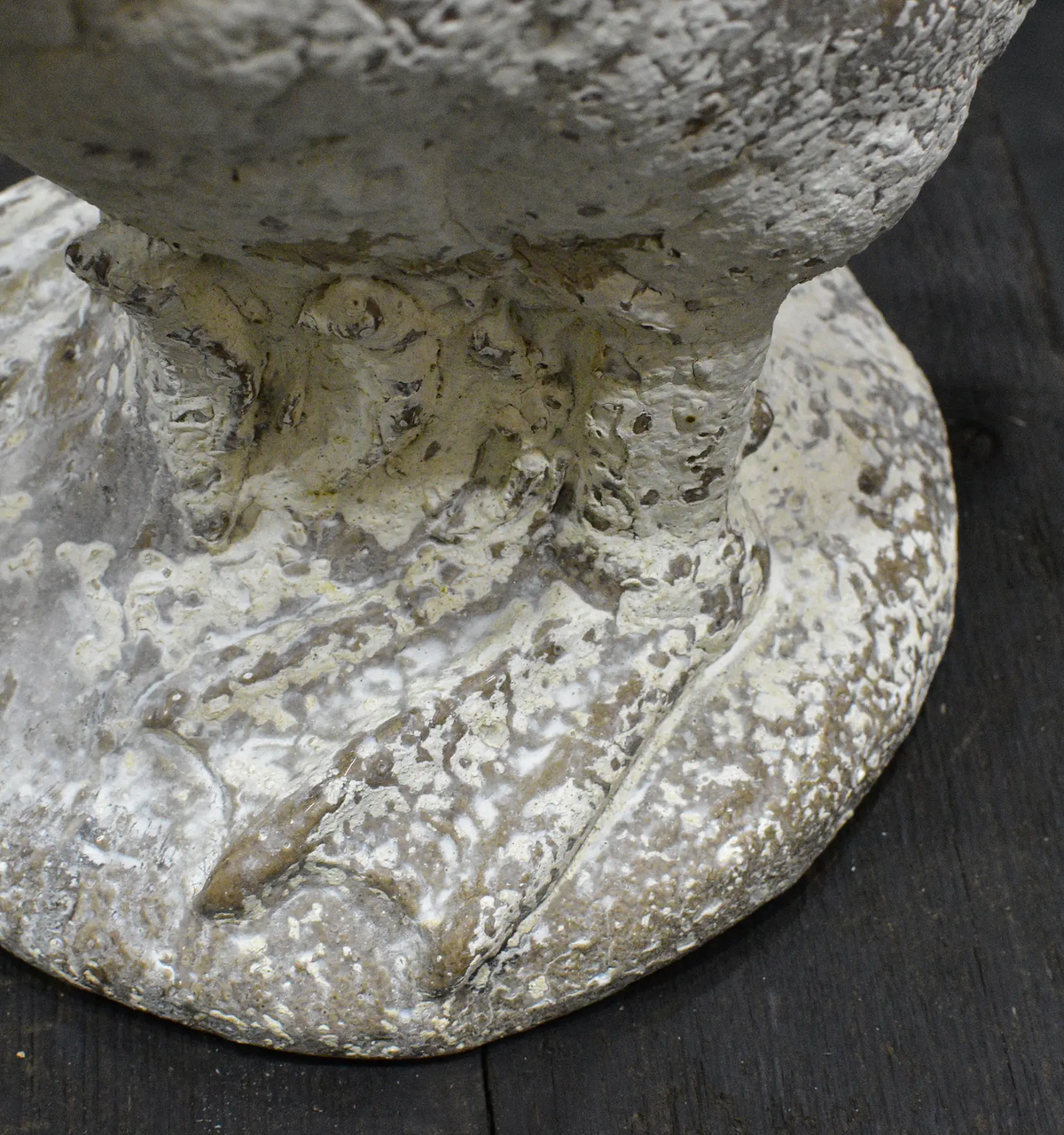 Close-up of goose statue feet and base showing rustic textured finish