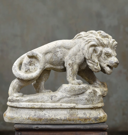 Side view of the lion statue showing its curled tail and raised front paw