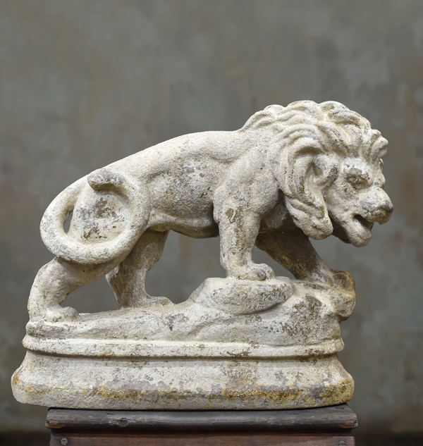 Side view of the lion statue showing its curled tail and raised front paw