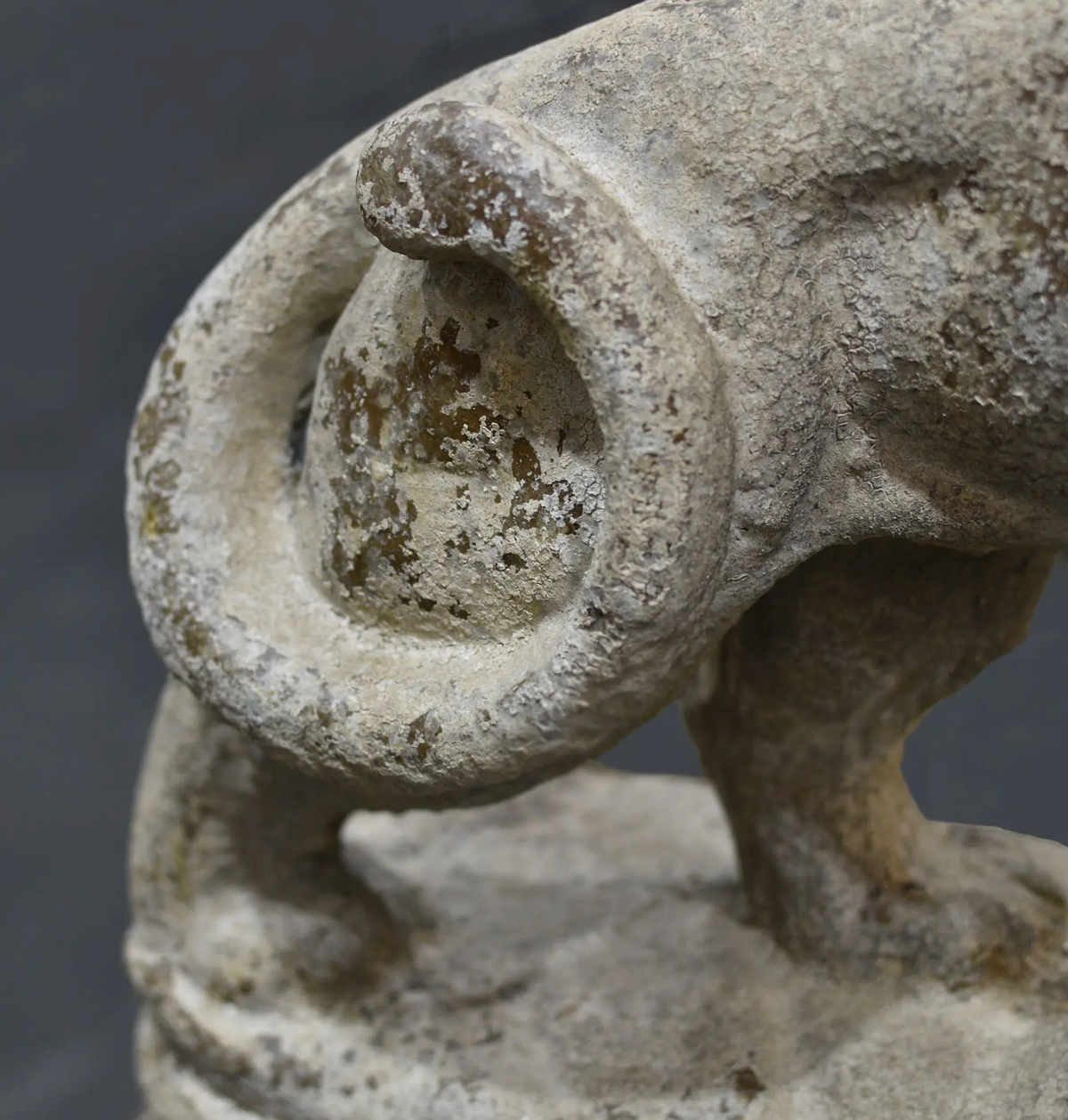 Close-up of the lion statue's curled tail and weathered finish
