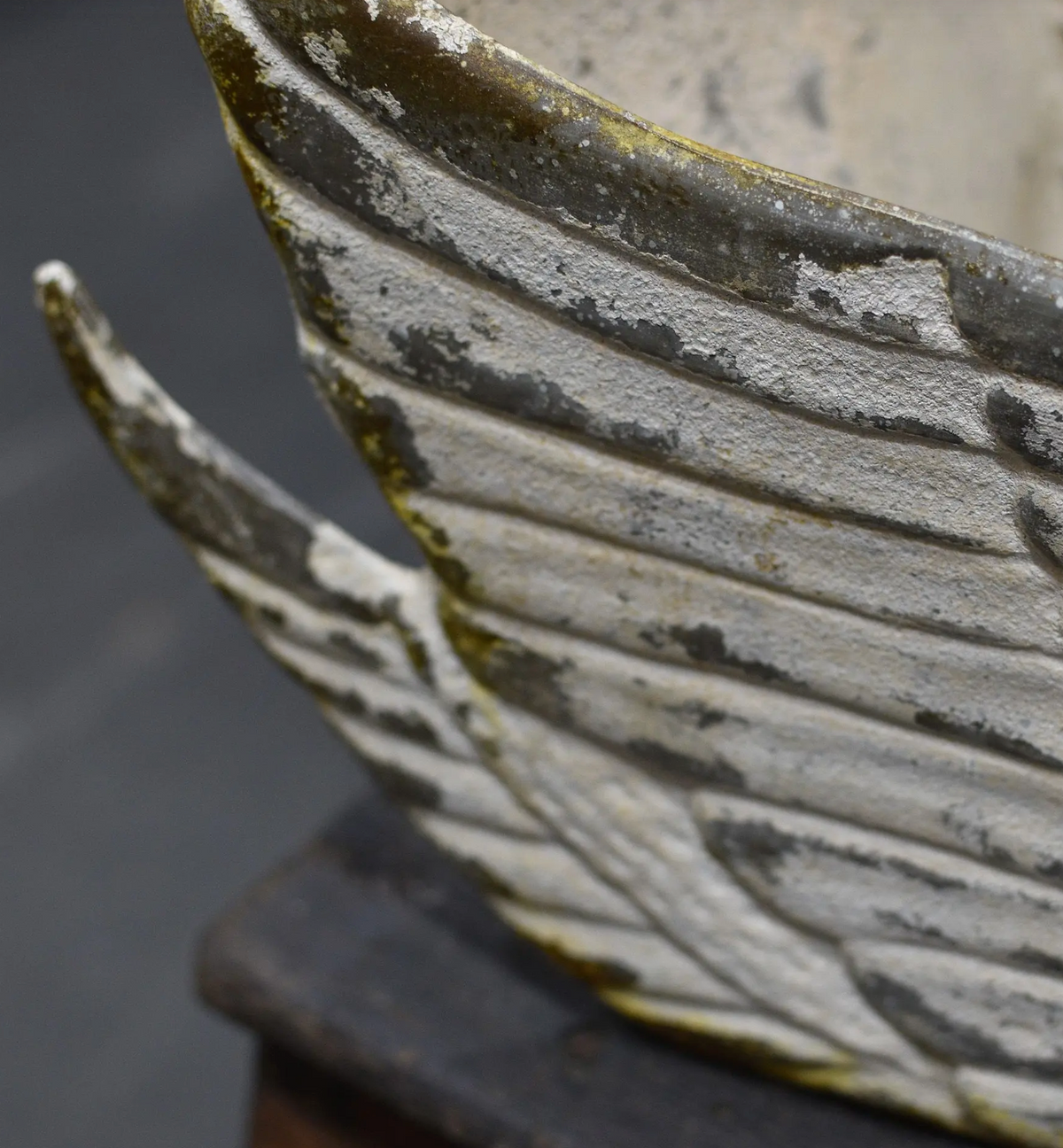 Close-up of raised feather detailing on the tin swan planter's wing