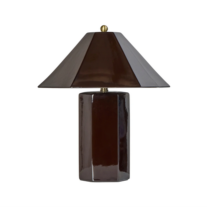 Brown faceted ceramic table lamp with angled shade and brass finial against a white background
