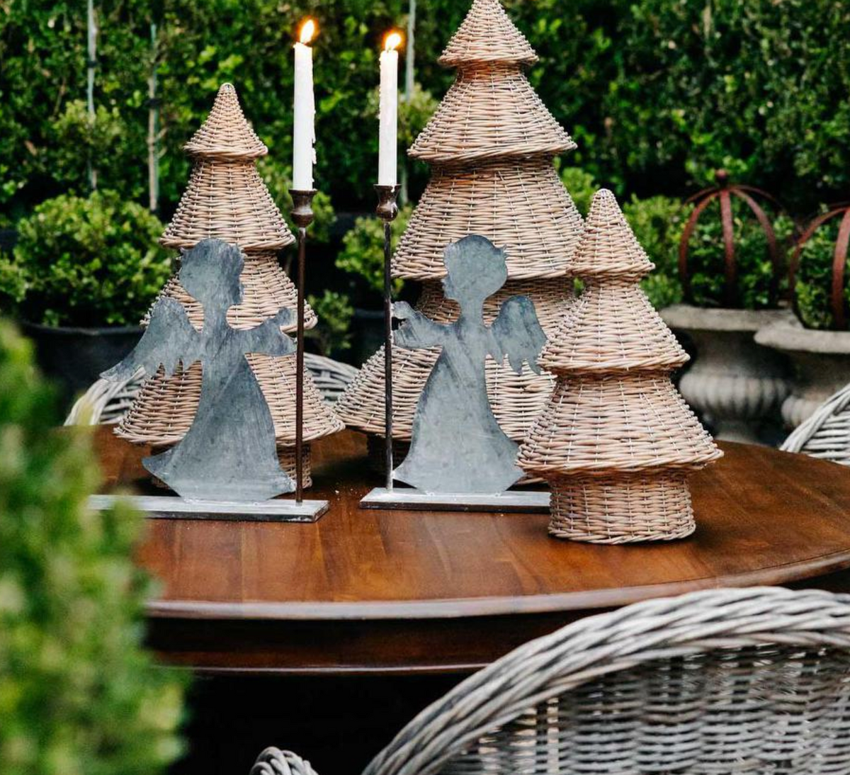 Willow Christmas trees arranged with metal angel decorations and candles