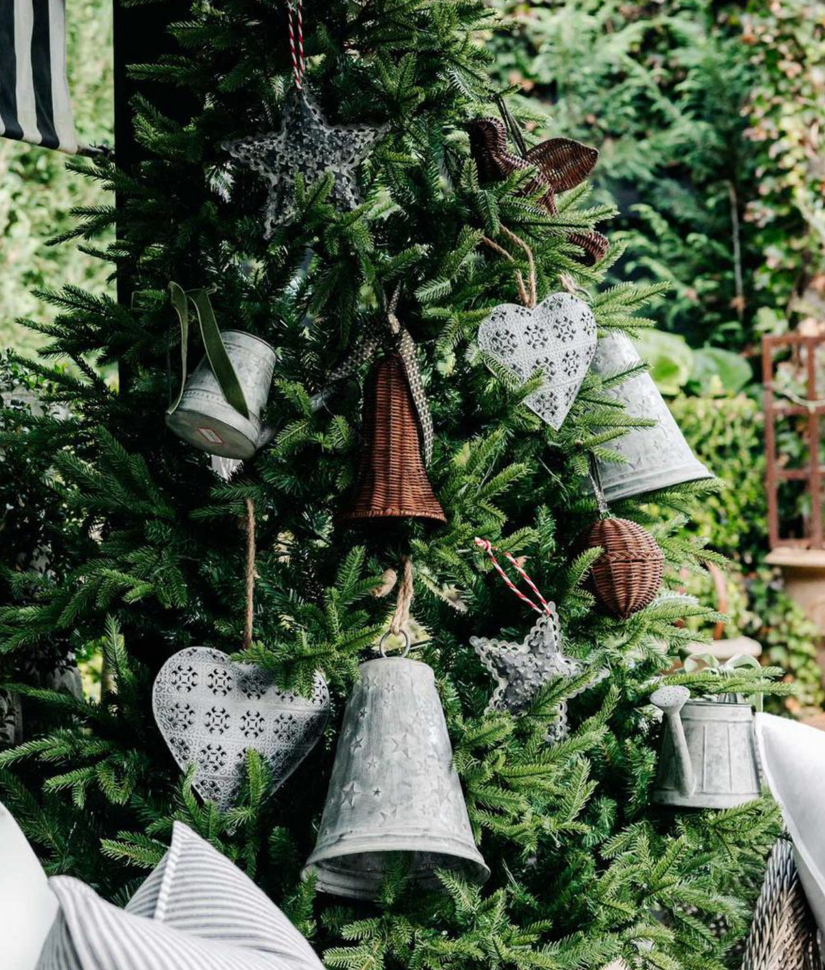 Star zinc bell hanging among Christmas greenery and other decorations