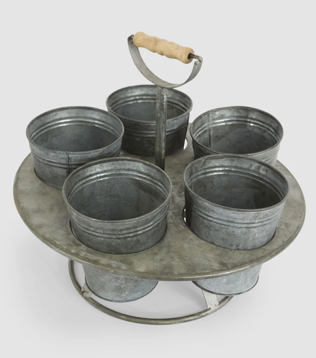 Angled view of zinc seedling holder showing five individual metal pots