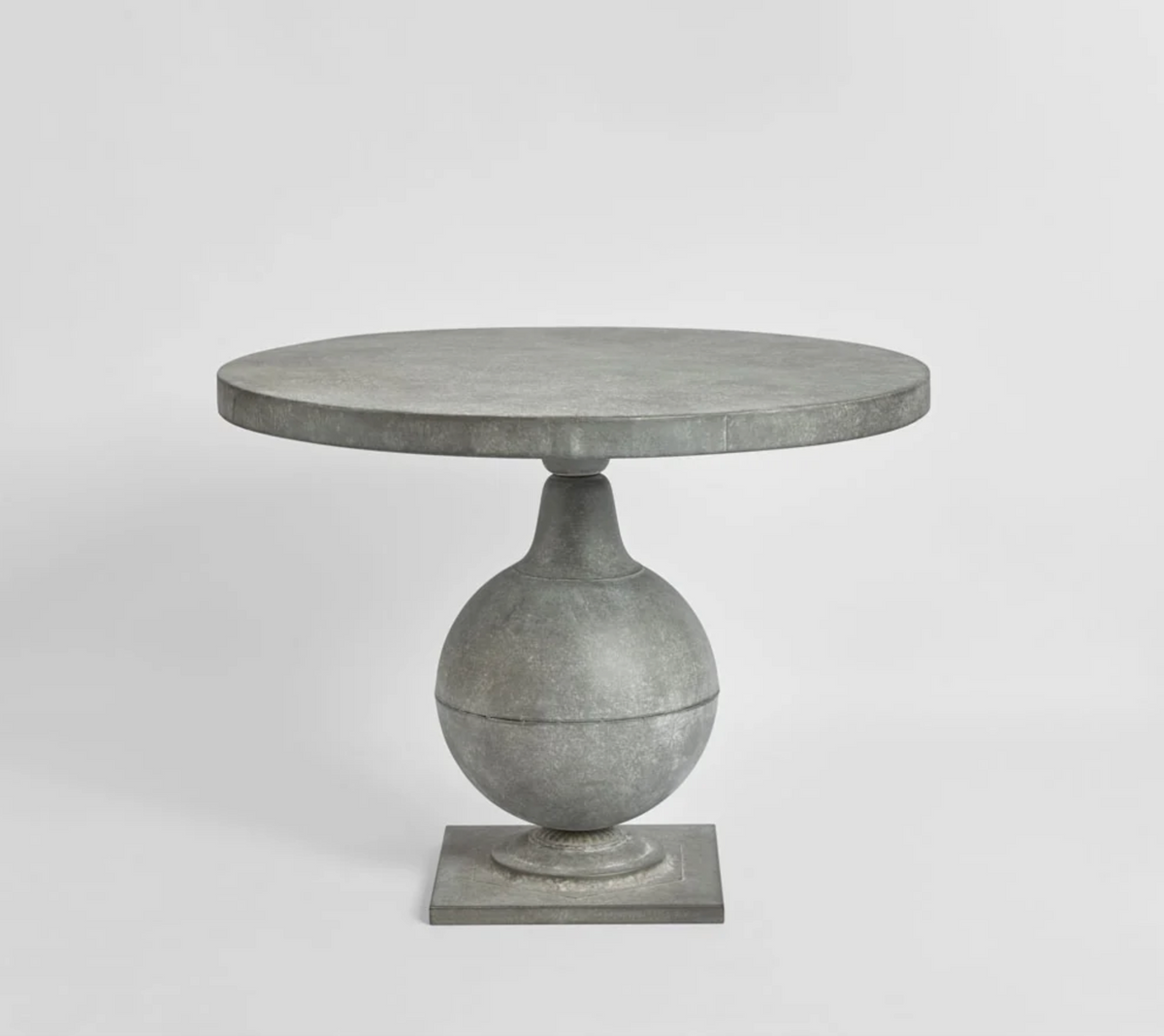 Zinc finish round table with curved pedestal base and square foot, front view
