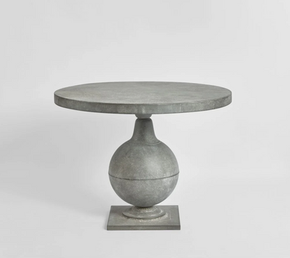 Zinc finish round table with curved pedestal base and square foot, front view