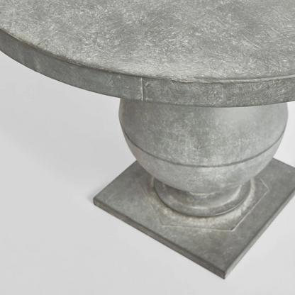 Close-up of the zinc finish tabletop edge, curved pedestal and square base