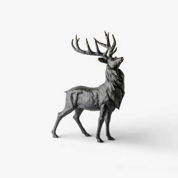 Antique black stag sculpture standing with its head raised and branching antlers
