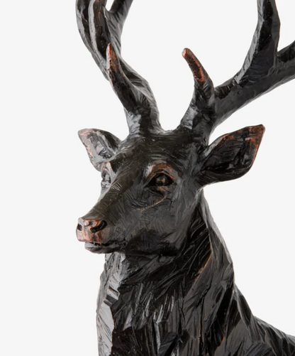 Close-up of the black stag sculpture showing its turned head, antlers and textured neck