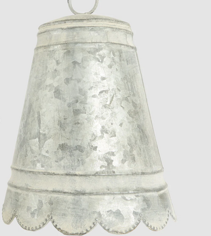 Close-up of small zinc bell showing mottled finish and scalloped edge