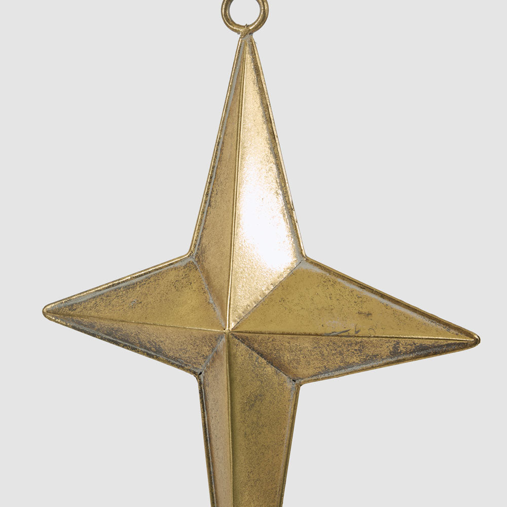 Large gold metal star hanging decoration in an angled view showing its folded metal shape