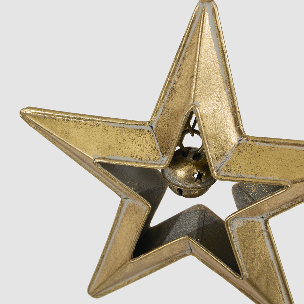 Small gold star with bell hanging decoration close-up showing the small round bell suspended inside the star