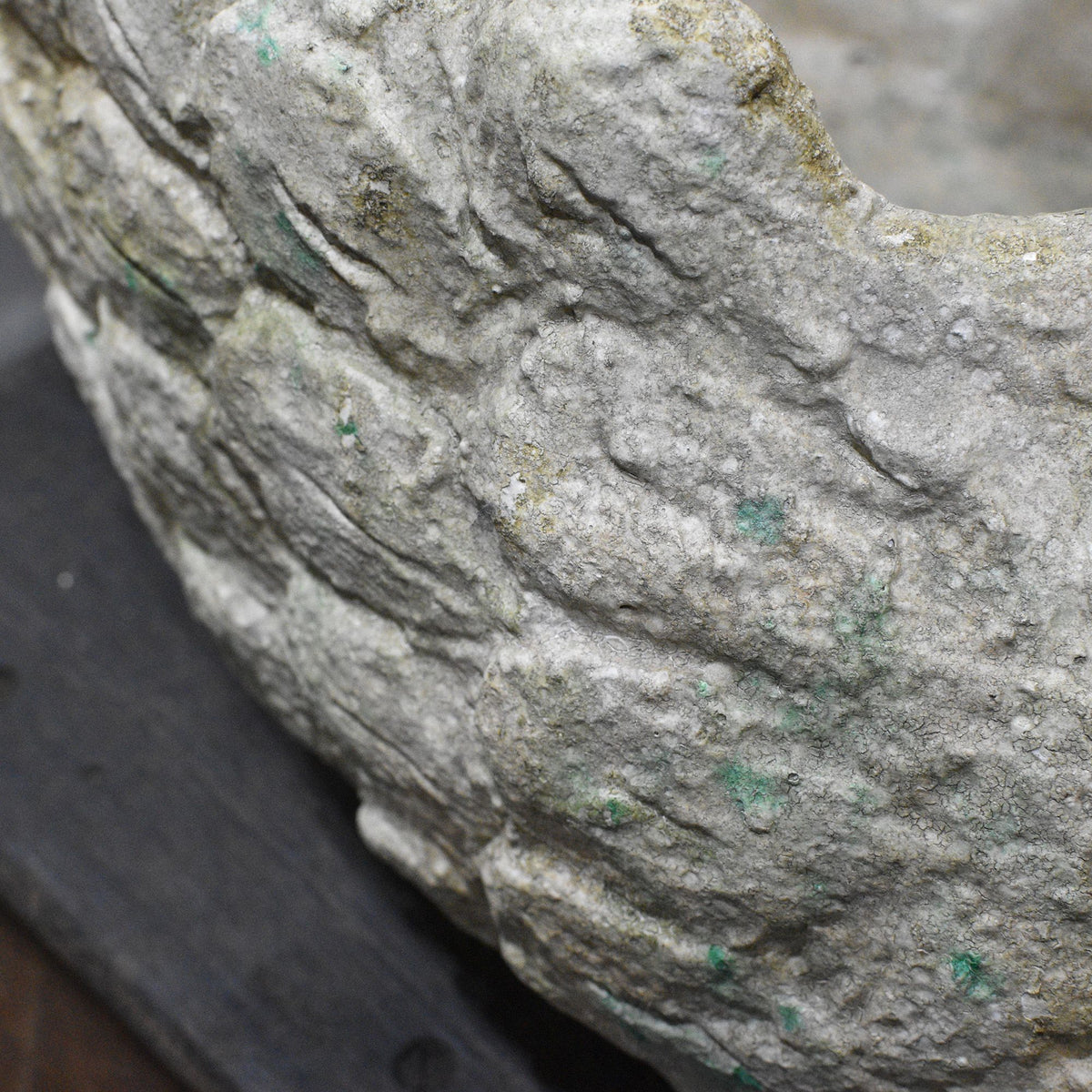 Close-up of moulded feather detail and aged finish on cement swan planter