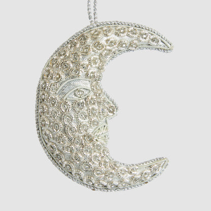 Silver crescent moon face hanging decoration with ornate floral embellishments and silver hanging cord