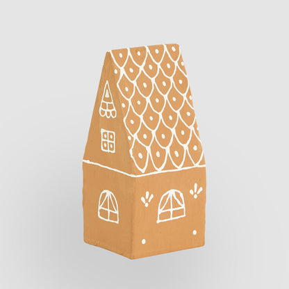 Rear view of the pitched-roof gingerbread house with white painted windows and dotted roof pattern