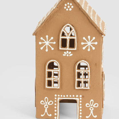 Close-up of the tall gingerbread house showing white window outlines and dotted doorway surround