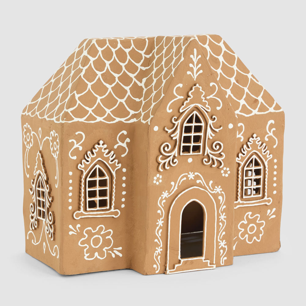 Front angled view of the large gingerbread house showing scalloped roof lines and decorative window surrounds