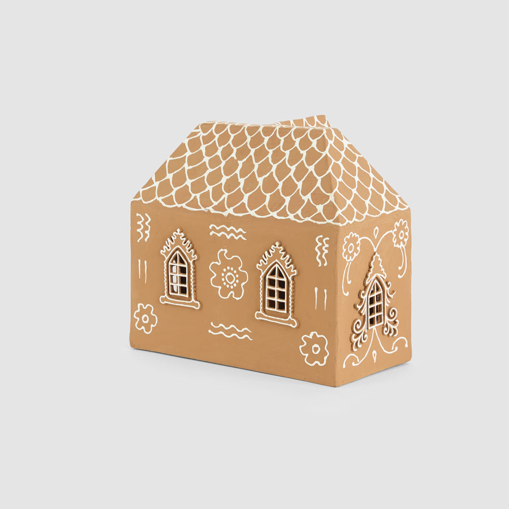 Rear view of the large gingerbread house showing white floral motifs, windows and scalloped roof pattern