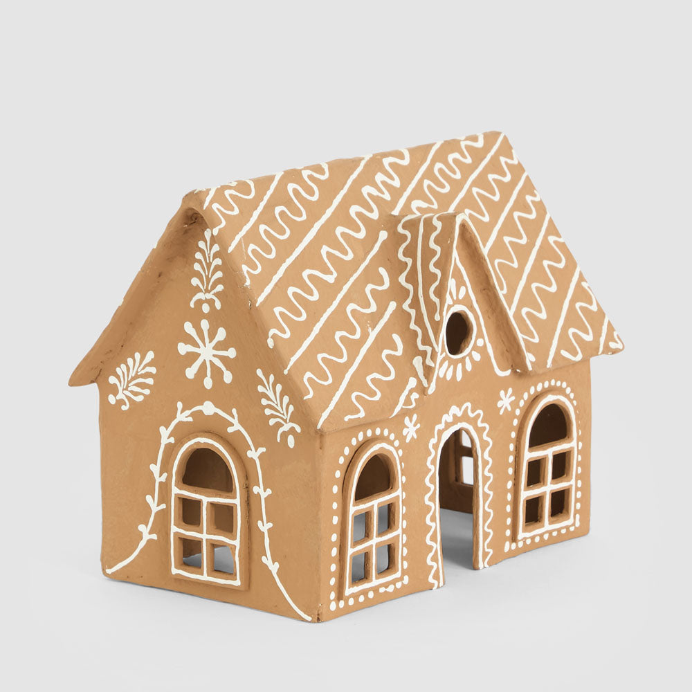 Angled view of the gingerbread cottage showing its patterned roof and decorated side wall